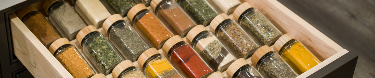 Maple spice drawer organizer insert holding two tiers of labelled spice jars